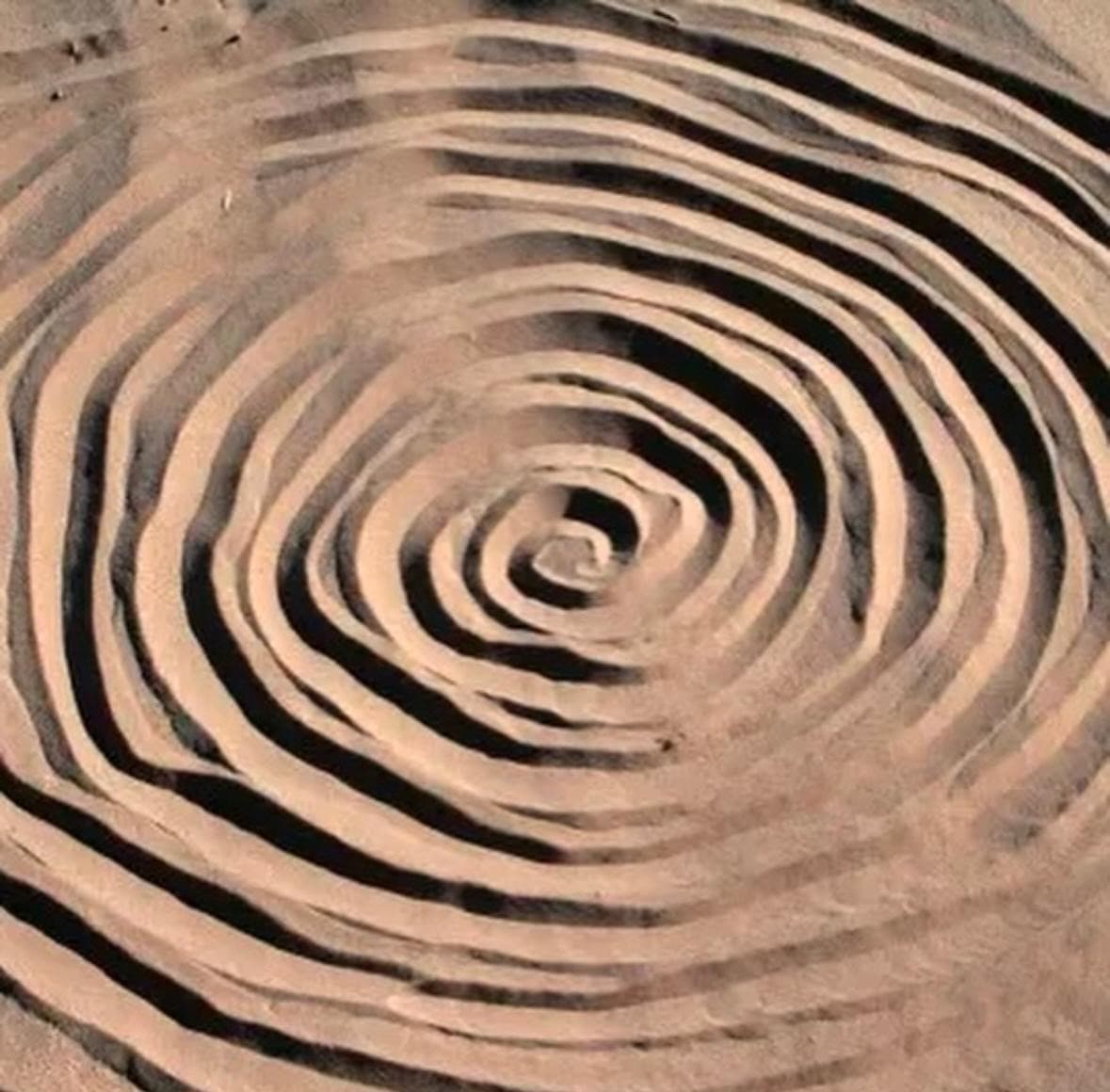 Concentric spiral carved into sand, earth art